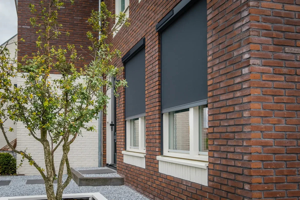 Screens en zonwering gemonteerd aan de buitengevel van een woning